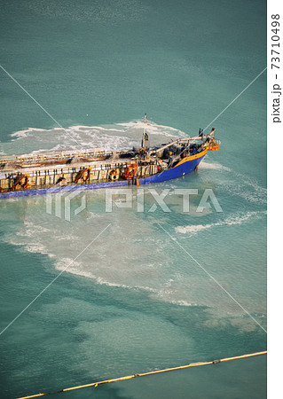 Suction Dredger Emptying Sluices, Spoiling Water of Gulf with mud Spot, Pollution, brown Muddy water - aerial shot Suction Dredger Emptying Sluices, Spoiling Water of Gulf with mud Spot, Pollution, brown Muddy water - aerial shot 73710498