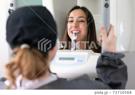 Young woman patient standing in x-ray machine. Young woman patient standing in x-ray machine. 73710568