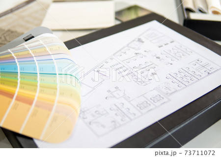 Interior designer's working table, an architectural plan of the house, a color palette. 73711072