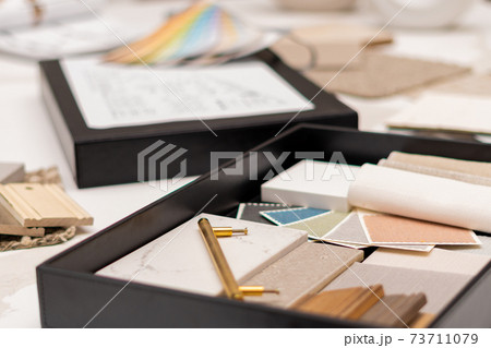 Interior designer's working table, an architectural plan of the house, a color palette. 73711079