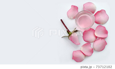 Pink flower and petals glass container with rose water, spa Natural skin care products. Feminine concept. Copy space Pink flower and petals glass container with rose water, spa Natural skin care products. Feminine concept. Copy space 73712102