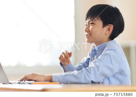 ノートPCを使っている笑顔の男の子 ノートPCを使っている笑顔の男の子 73715880