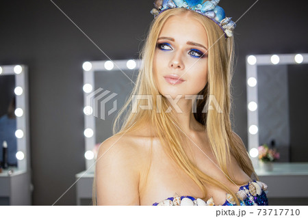 Woman with blond hair and blue eyes in room with mirrors Woman with blond hair and blue eyes in room with mirrors 73717710