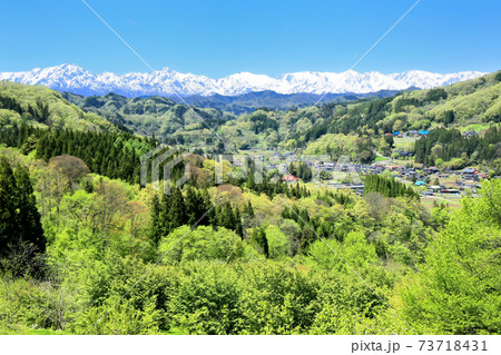 新緑の集落と北アルプス 73718431