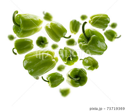Green paprika in the shape of a heart on a white background 73719369