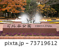 日比谷公園の入り口の銘板、秋の紅葉と噴水が背景 73719612