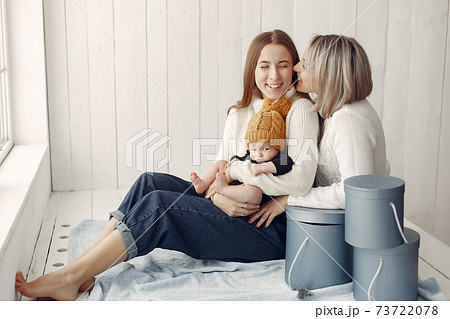 Elegant grandma at home with daughter and grandson 73722078