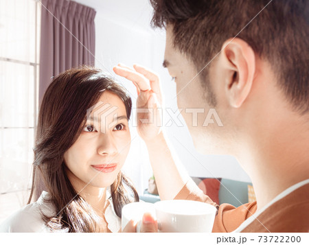 Asian woman and man are enjoying spending time together at home with coffee under sunlight. 73722200