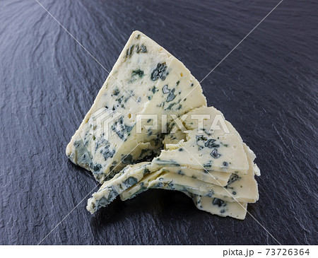 Cheese with mold on a board of stone. Gorgonzola cheese close-up on a surface of slate. 73726364