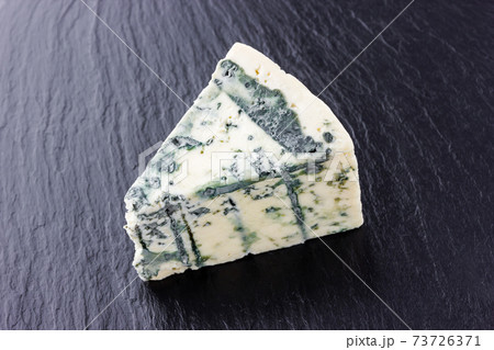 Cheese with mold on a board of stone. Gorgonzola cheese close-up on a surface of slate. 73726371