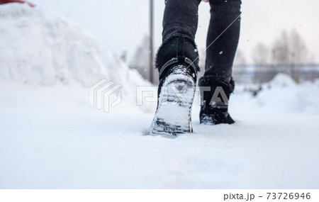A person is walking on a slippery road, the first snow in the park A person is walking on a slippery road, the first snow in the park 73726946