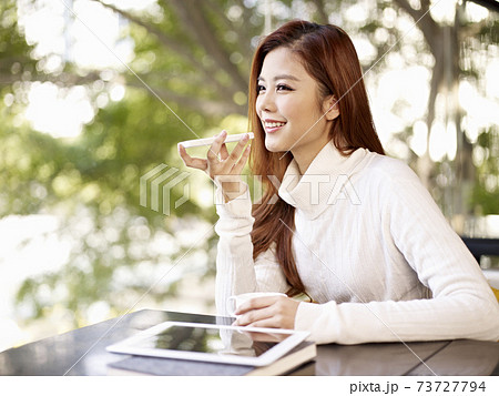 young woman leaving voice message using mobile phone young woman leaving voice message using mobile phone 73727794