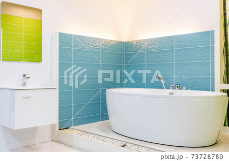 White and wooden bathroom corner with a white bathtub, a toilet and a built in shelf for self care products White and wooden bathroom corner with a white bathtub, a toilet and a built in shelf for self care products 73728780