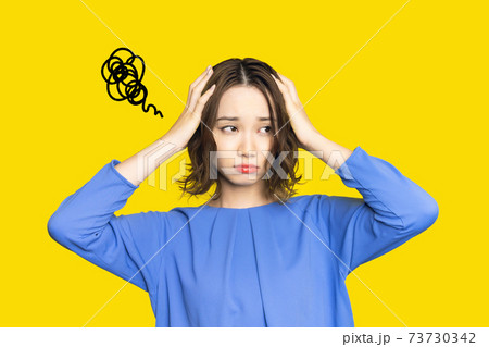 落ち込む女性　戸惑い　困惑　頭痛 73730342