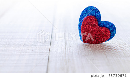 Happy days background. Red love hearts, Valentines day candle on wooden table. Romantic message template with copy space. 73730671