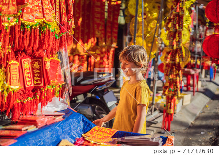Caucasian tourist boy in Tet holidays. Vietnam Chinese Lunar New Year in springtime. TEXT TRANSLATION from Vietnamese: Congratulations on the Vietnamese, Chinese New Years and wishes of all the best Caucasian tourist boy in Tet holidays. Vietnam Chinese Lunar New Year in springtime. TEXT TRANSLATION from Vietnamese: Congratulations on the Vietnamese, Chinese New Years and wishes of all the best 73732630