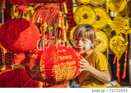 Caucasian tourist boy in Tet holidays. Vietnam Chinese Lunar New Year in springtime. TEXT TRANSLATION from Vietnamese: Congratulations on the Vietnamese, Chinese New Years and wishes of all the best Caucasian tourist boy in Tet holidays. Vietnam Chinese Lunar New Year in springtime. TEXT TRANSLATION from Vietnamese: Congratulations on the Vietnamese, Chinese New Years and wishes of all the best 73732645