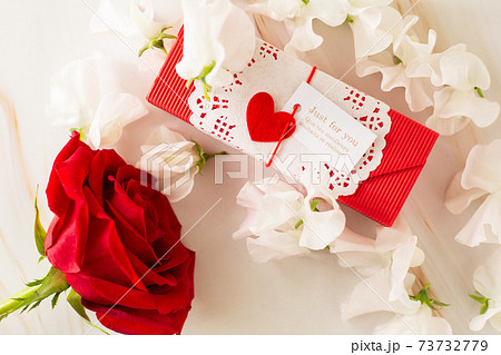 赤い薔薇 白いスイトピーとギフトボックスの写真素材