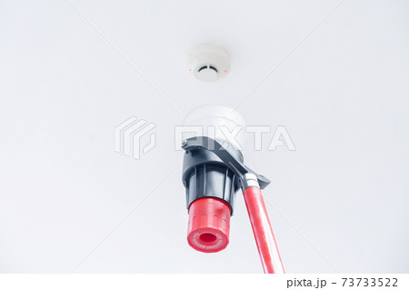 Automatic smoke detector fire alarm head on the ceiling. The smoke detector is triggered by a trickle of dum, the red indicator lights up 73733522