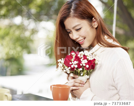 young asian woman in love holding flowers and smiling, valentine's day theme 73733687