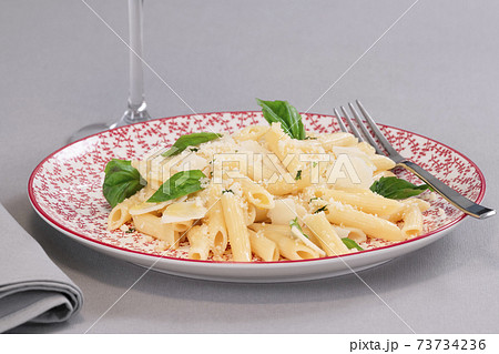 tempting cooked pasta with cheese and herbs on a plate 73734236