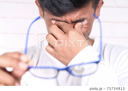 Close up of upset man suffering from strong eye pain Close up of upset man suffering from strong eye pain 73734813