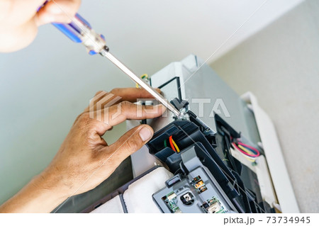 Technician repairing air conditioner with screwdriver, installation electric wires of the air conditioner 73734945