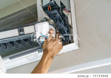 Service technician is cleaning, repair and maintenance of air conditioner 73734946