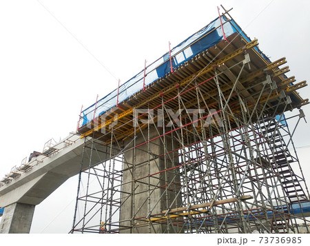 PENANG, MALAYSIA - MARCH 21, 2020: Overhead road under construction. The massive concrete column used to support the concrete road deck. Construction work is in full swing. PENANG, MALAYSIA - MARCH 21, 2020: Overhead road under construction. The massive concrete column used to support the concrete road deck. Construction work is in full swing. 73736985