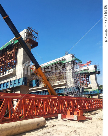 PENANG, MALAYSIA - MARCH 21, 2020: Overhead road under construction. The massive concrete column used to support the concrete road deck. Construction work is in full swing. PENANG, MALAYSIA - MARCH 21, 2020: Overhead road under construction. The massive concrete column used to support the concrete road deck. Construction work is in full swing. 73736986