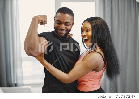 Handsome Afro American couple working out at home Handsome Afro American couple working out at home 73737247