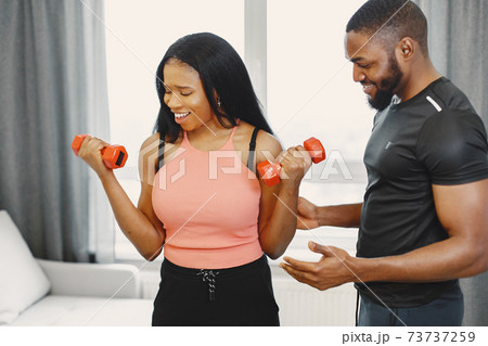 Handsome Afro American couple working out at home Handsome Afro American couple working out at home 73737259