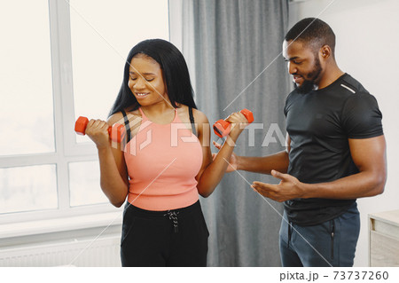 Handsome Afro American couple working out at home Handsome Afro American couple working out at home 73737260