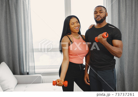 Handsome Afro American couple working out at home Handsome Afro American couple working out at home 73737261