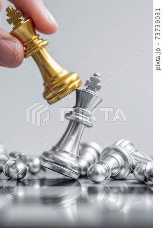 businessman hand moving gold Chess King figure and Checkmate enermy or opponent during chessboard competition. Strategy, Success, management, business planning, interruption and leadership concept 73739031