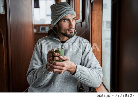Man smiling and drinking coffee in the morning at the boat Man smiling and drinking coffee in the morning at the boat 73739307