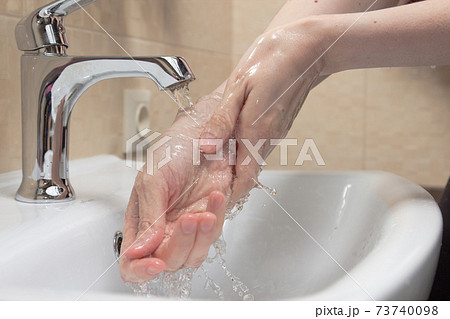 Hygiene. Cleaning Hands. Washing hands with clean water. Woman's hand. Protect yourself from coronavirus COVID-19 pandemia. Close-up photo. 73740098
