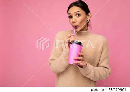 Photo shot of beautiful young happy brunette woman wearing beige sweater isolated over pink Photo shot of beautiful young happy brunette woman wearing beige sweater isolated over pink 73740961