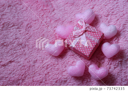 ピンクの毛布に置いたハート型の梱包材の写真素材