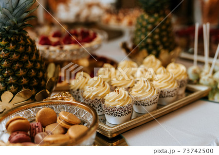 Closeup of a wedding candybar with cakes and fruits Closeup of a wedding candybar with cakes and fruits 73742500