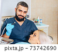 A frightened blonde girl at a reception at a cheerful dentist. 73742690