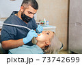 A girl at the reception of a male dentist in a dental chair 73742699