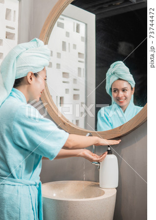 asian girl smiles washing hands with soap in the sink asian girl smiles washing hands with soap in the sink 73744472