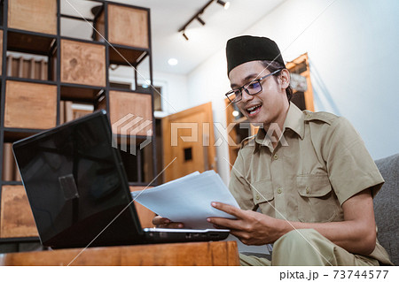man in government uniform holding papers while working from home online man in government uniform holding papers while working from home online 73744577