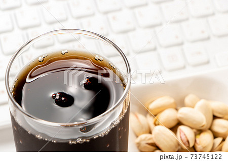 コークハイ。写真奥にはピスタチオとキーボード。オンライン飲み会イメージ。 コークハイ。写真奥にはピスタチオとキーボード。オンライン飲み会イメージ。 73745122