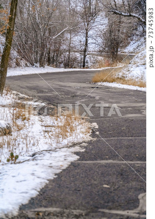 Weathered road on mountain with snow in winter 73745983