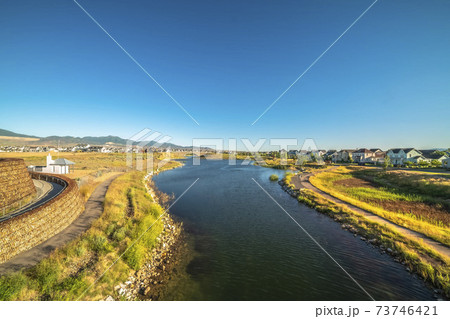 Paved trails along a winding lake with houses and mountain in the distance Paved trails along a winding lake with houses and mountain in the distance 73746421
