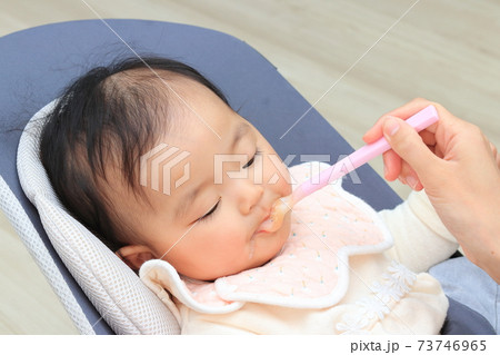 リビングで離乳食を食べさせてもらう赤ちゃん リビングで離乳食を食べさせてもらう赤ちゃん 73746965