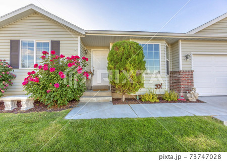 Exterior of one storey single family home with a beautiful front garden Exterior of one storey single family home with a beautiful front garden 73747028