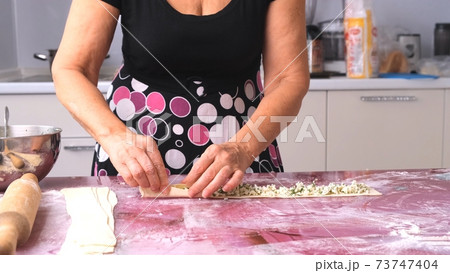 Female hands make burgers, khachapuri with cheese and herbs from the dough. the process of making 73747404